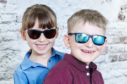 Zwei Kinder mit stylischen Sonnenbrillen und guter Laune