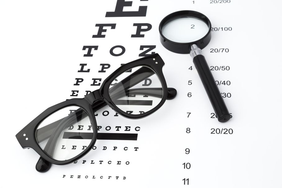 Sehtesttafel mit Brille und Lupe zur Vorbereitung auf die Augenprüfung